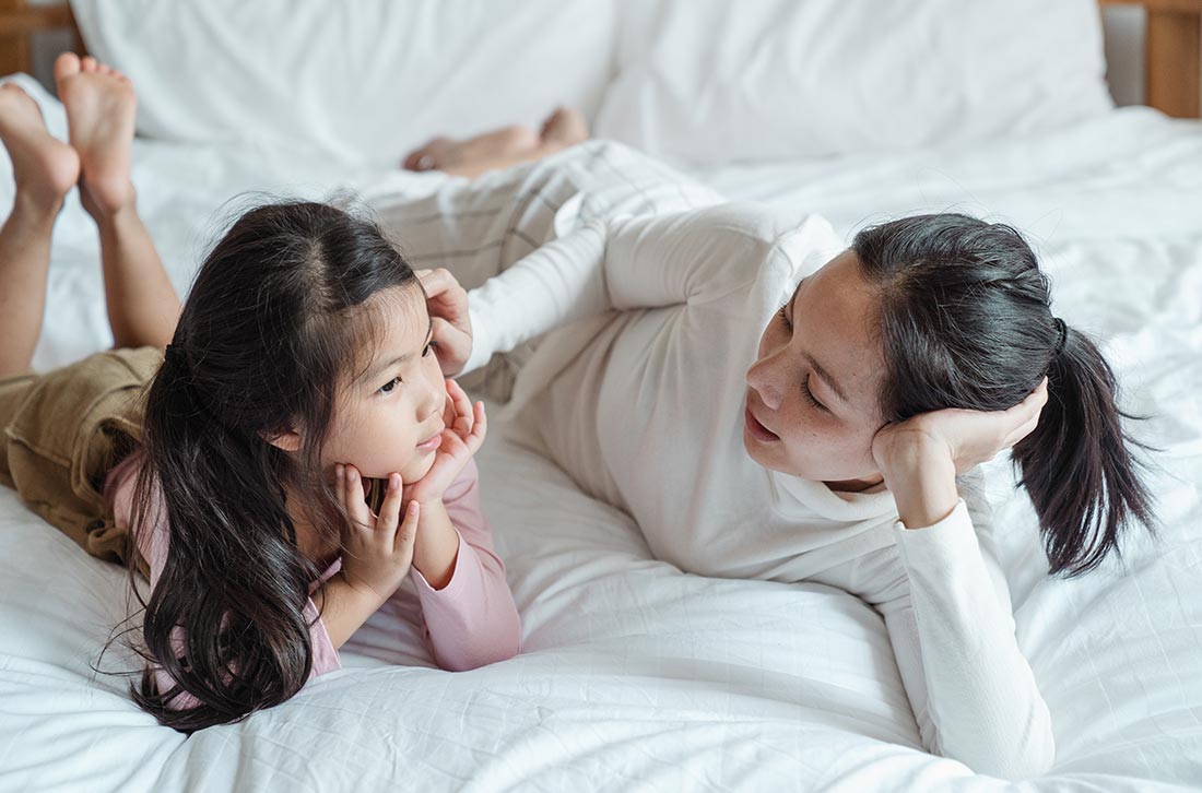 mère et fille allongée sur le lit et qui discutent des premieres regles mère et fille allongée sur le lit et qui discutent des premieres regles